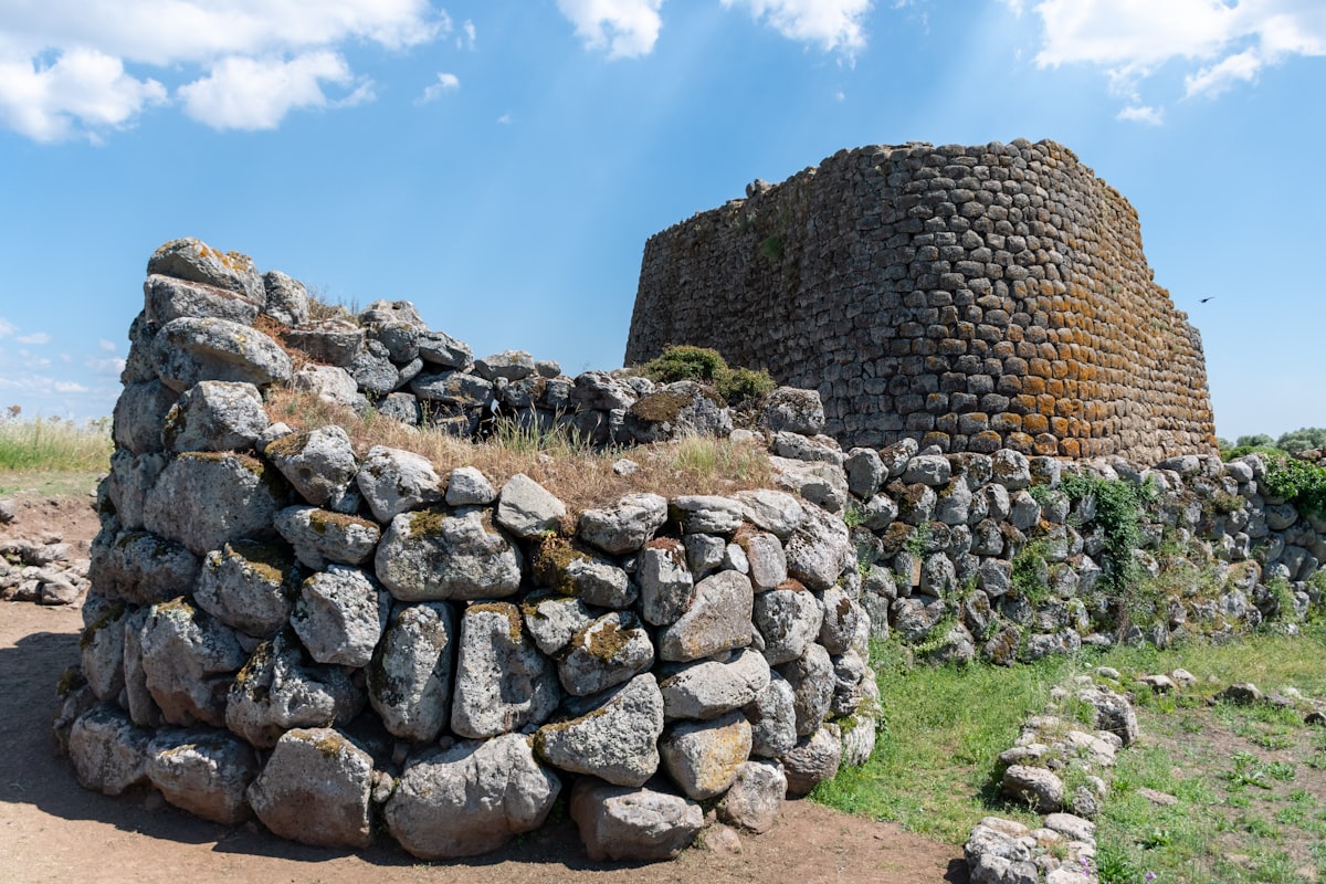 A large stone structure sitting on top of a dirt field