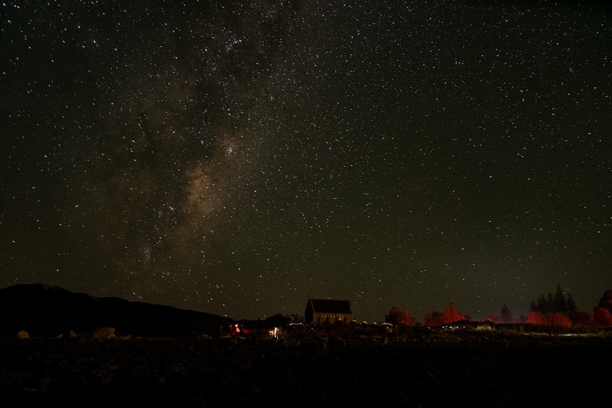 The night sky is filled with stars above a town