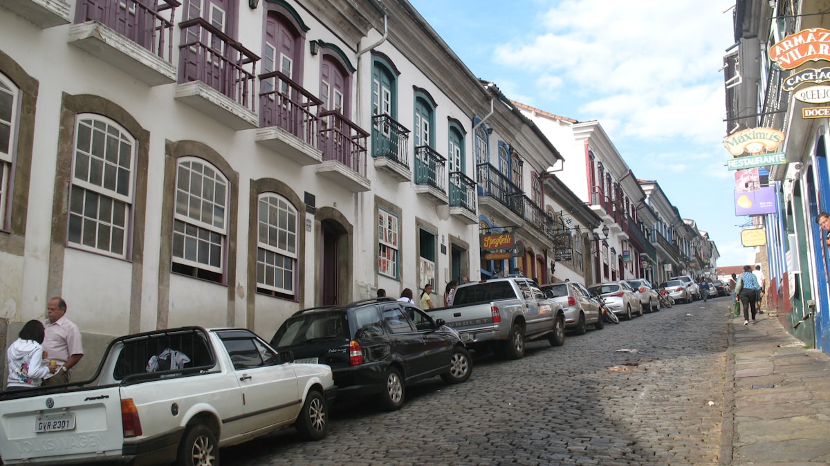 a row of parked cars on a cobblestone street