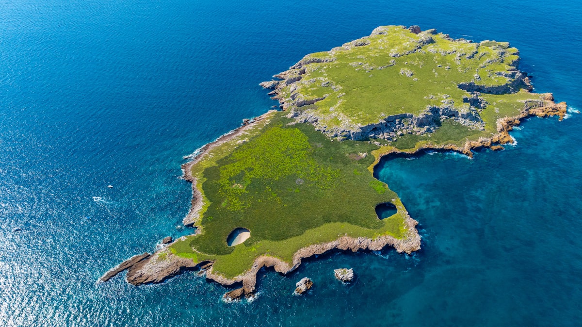 Aerial view of a green island surrounded by blue ocean