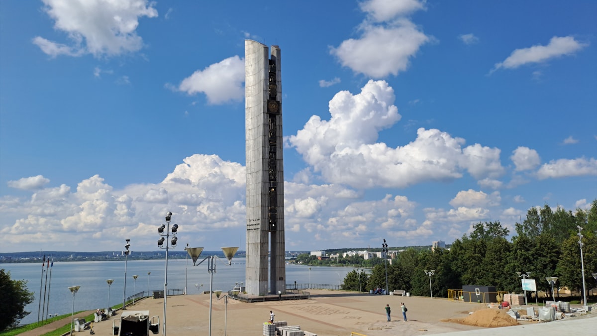 Tall modern sculpture beside a body of water