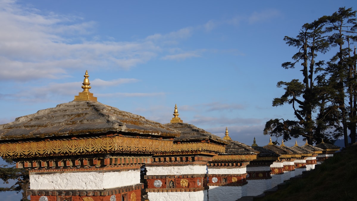 Traditional bhutanese architecture with ornate roofs against blue sky.