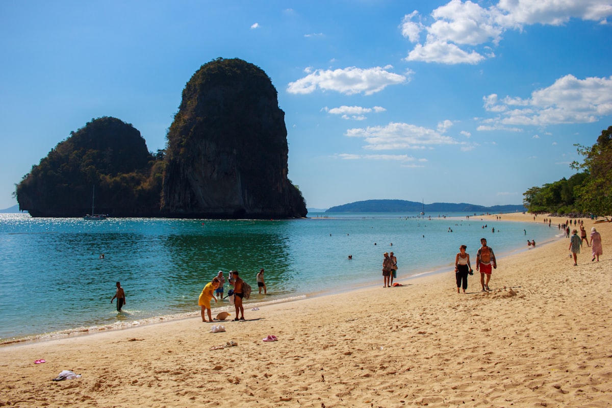 a group of people walking along a sandy beach