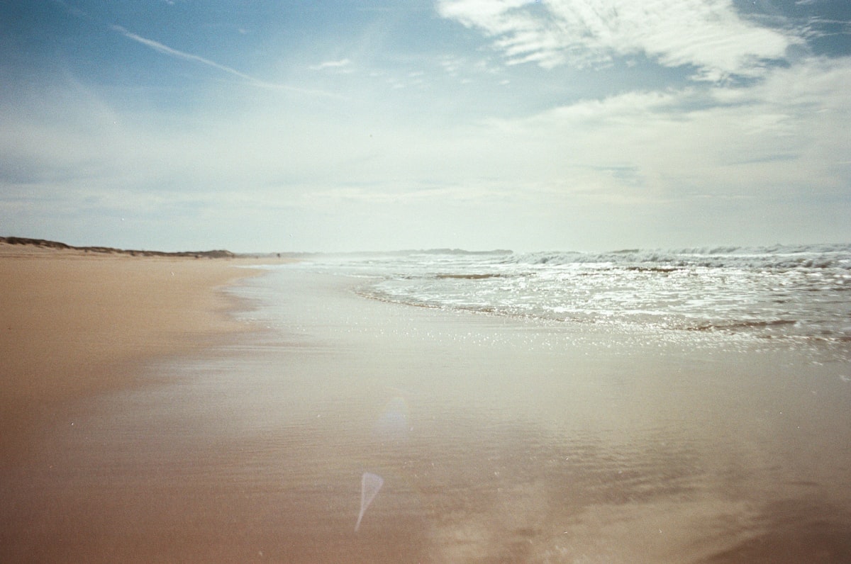 a sandy beach with waves crashing on it
