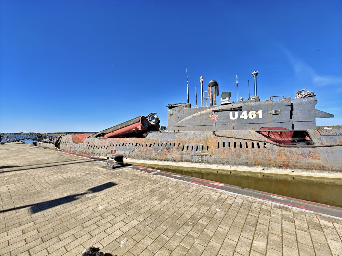 A rusty submarine rests on a sunny day.