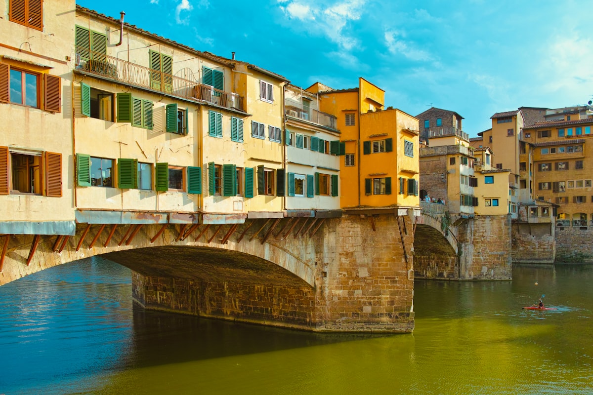 A bridge over a body of water with buildings in the background