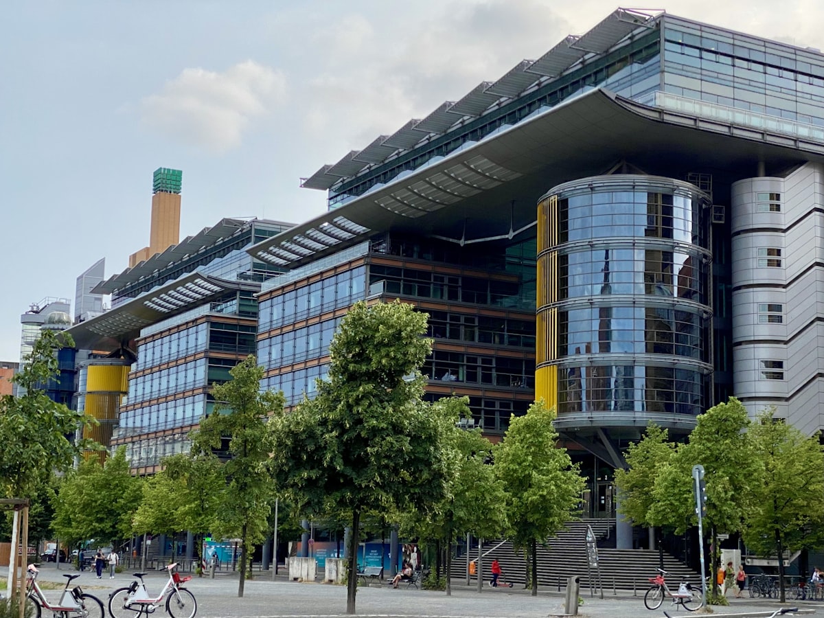 a large building with a lot of windows next to trees