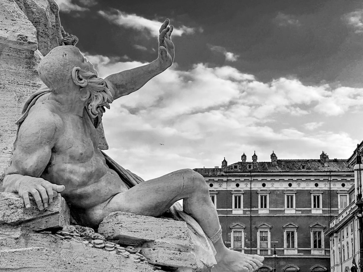 A statue of a man sitting on top of a rock