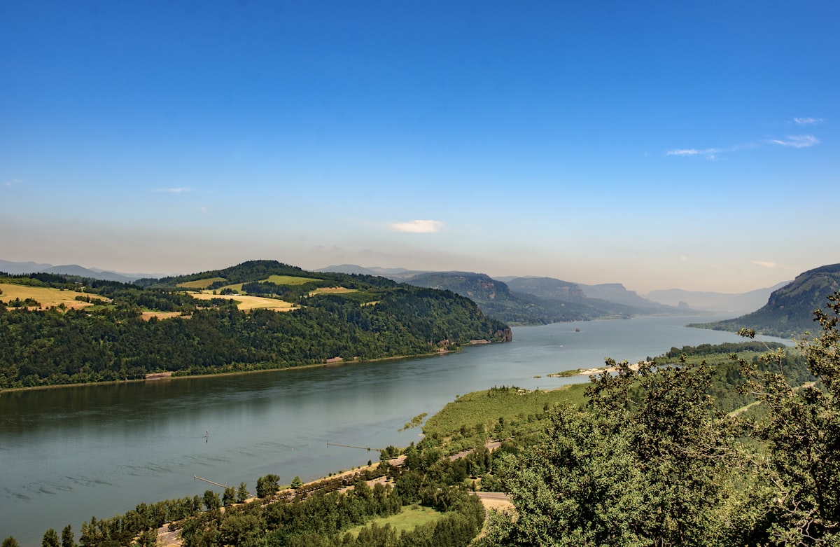 A wide river flows through lush mountains.
