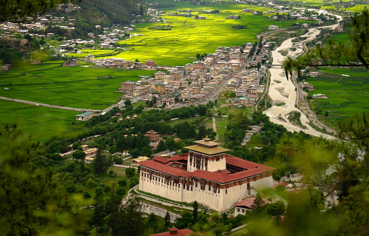 A fortress and village nestled in a green valley.