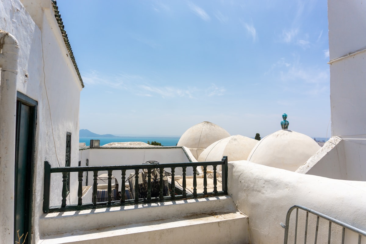 A balcony with a railing and a view of the ocean