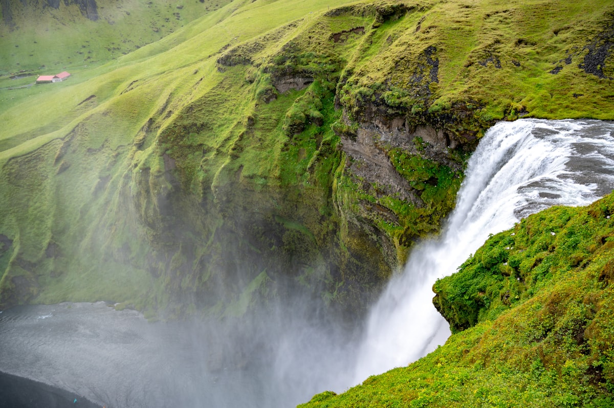 A waterfall in the middle of a lush green valley