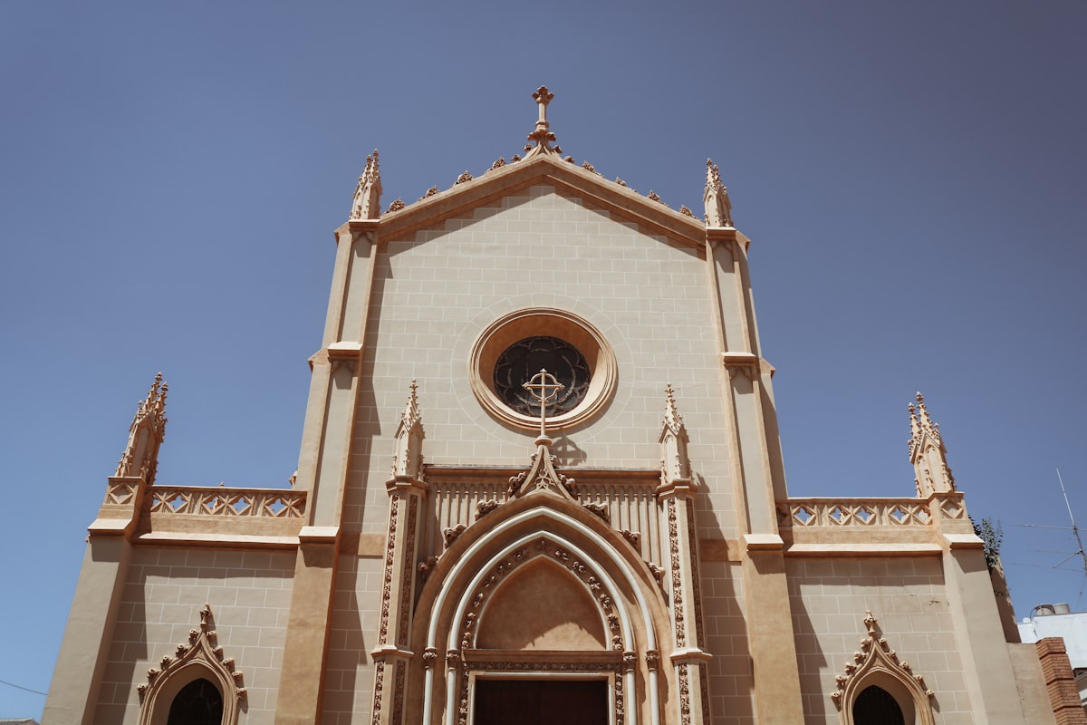Facade of a pale stone church against a blue sky