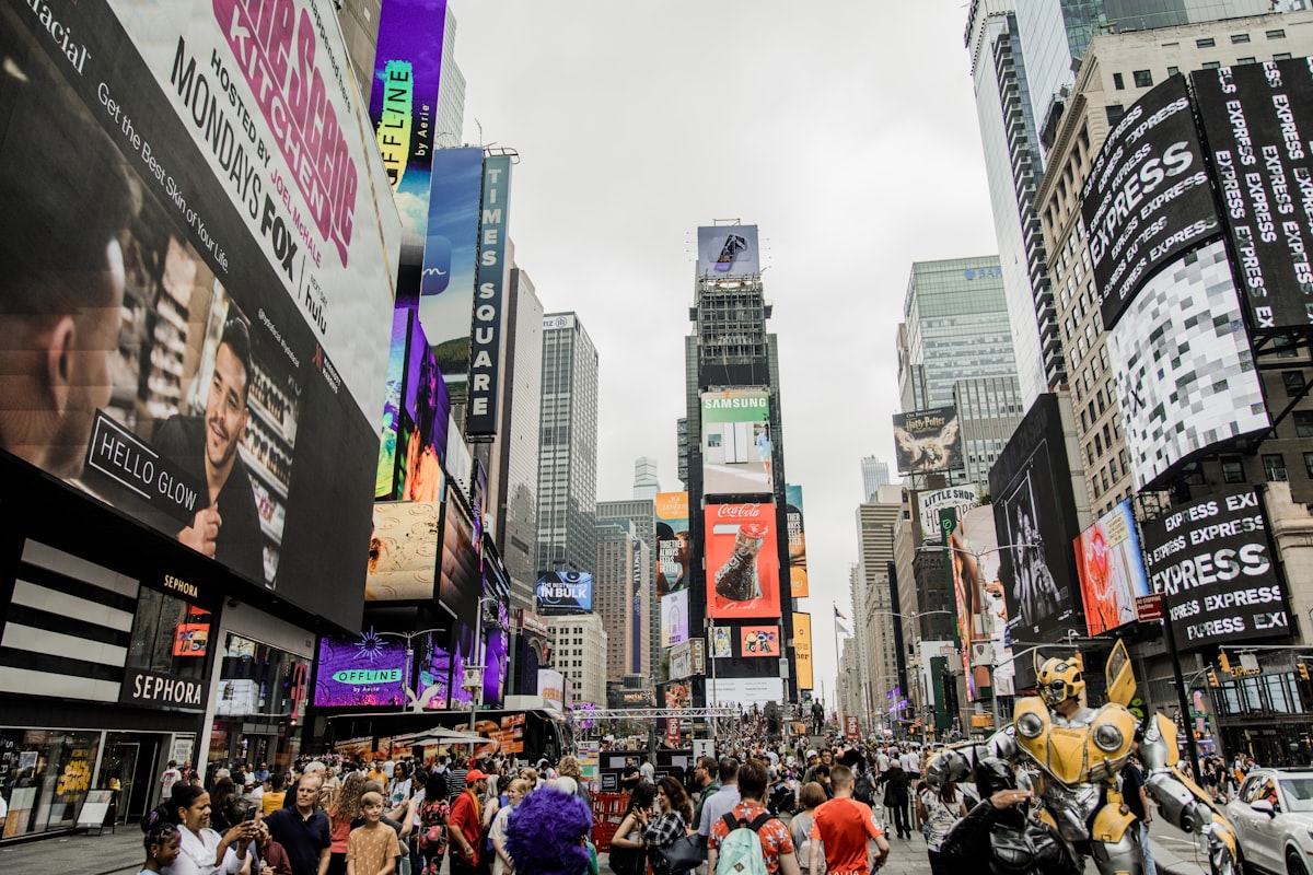 a crowd of people walking down a street next to tall buildings
