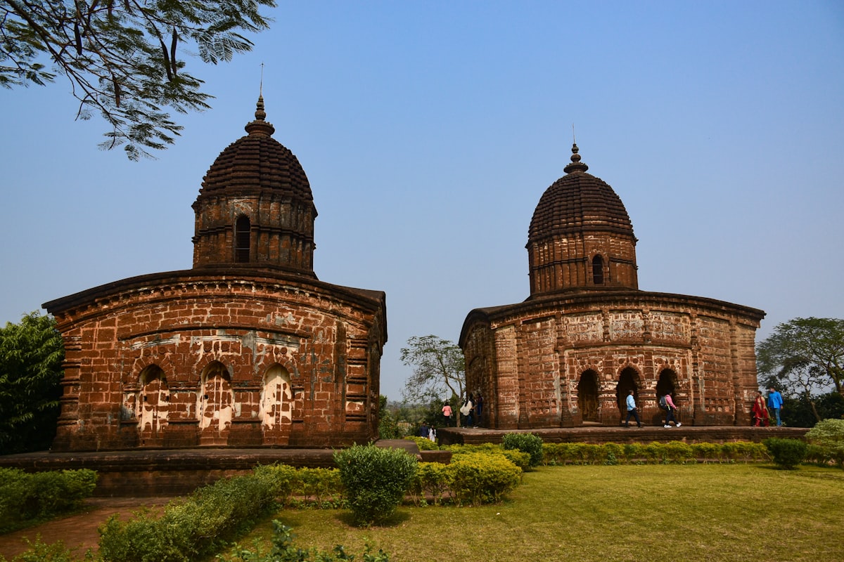 a couple of large brick buildings sitting on top of a lush green field