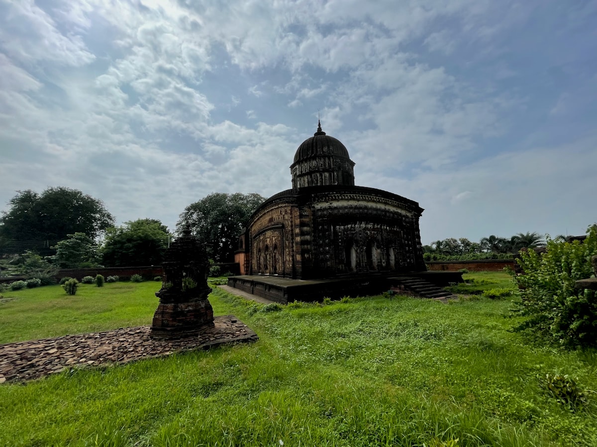 brown concrete building under white clouds during daytime