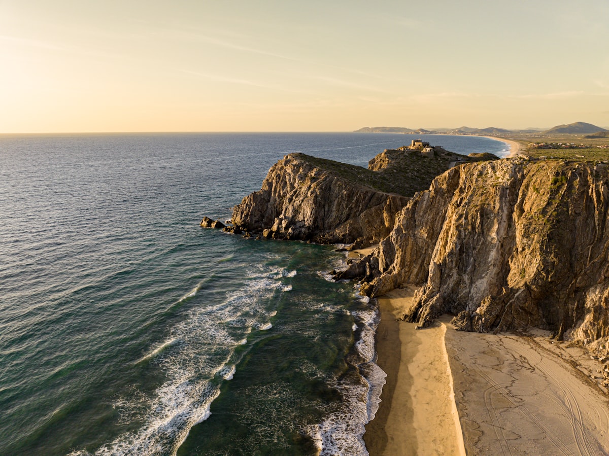 a rocky beach with a body of water and a sandy beach