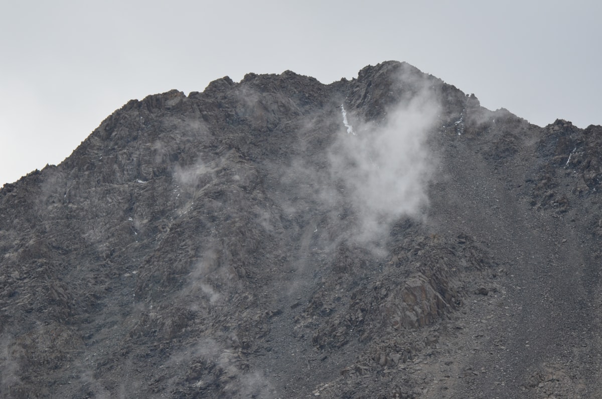 a very tall mountain with some clouds coming out of it