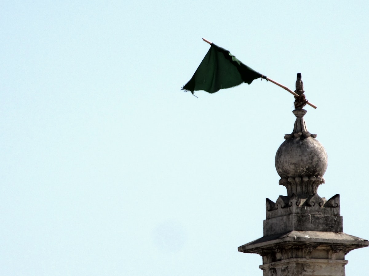 a flag on top of a building with a sky background