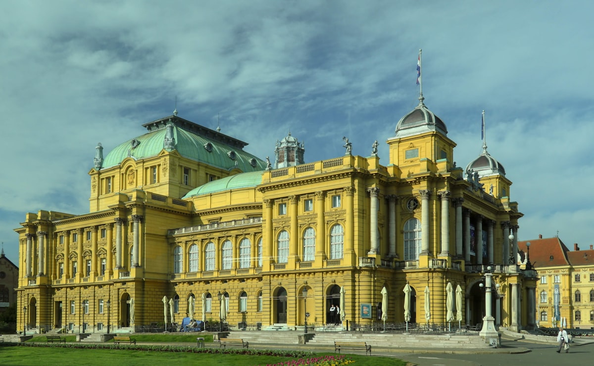 a large yellow building with a green roof