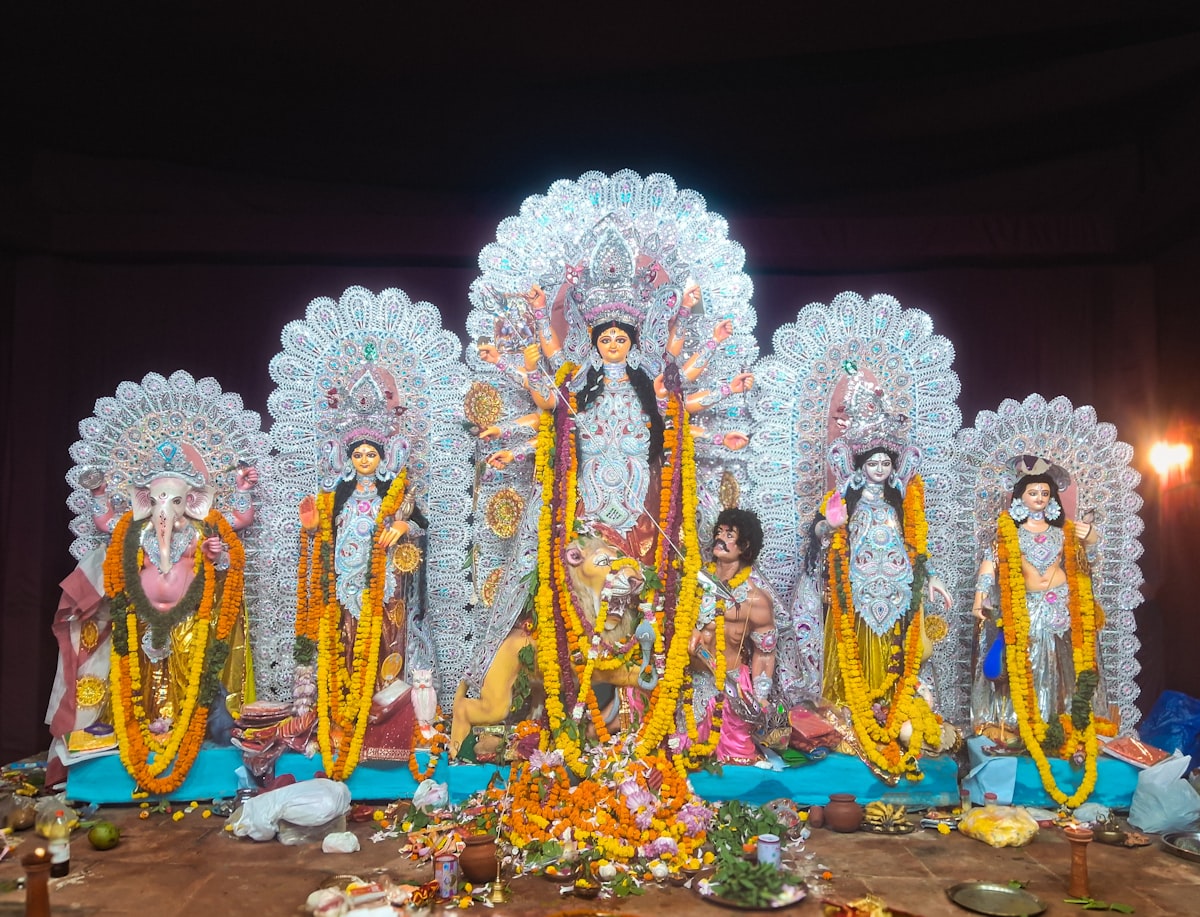 Durga puja idols adorned with flowers and decorations.