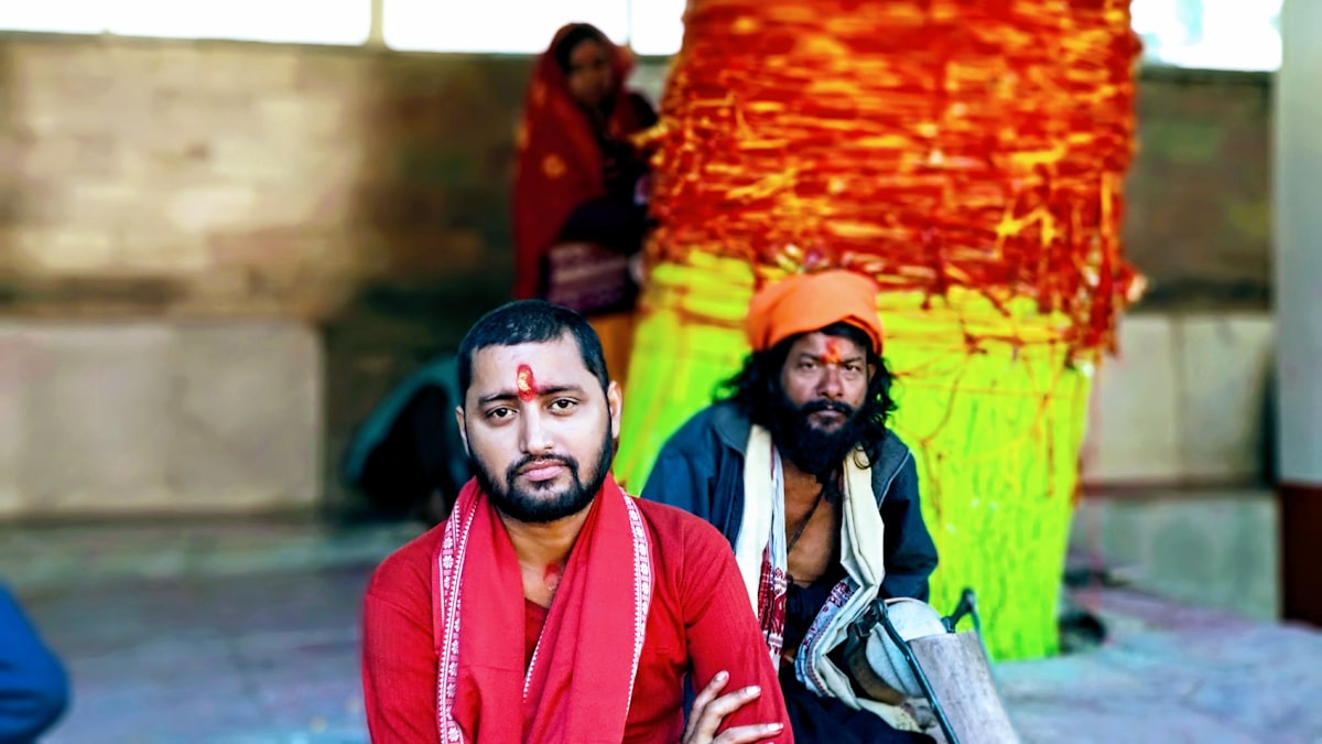 two men sitting near red and green decor