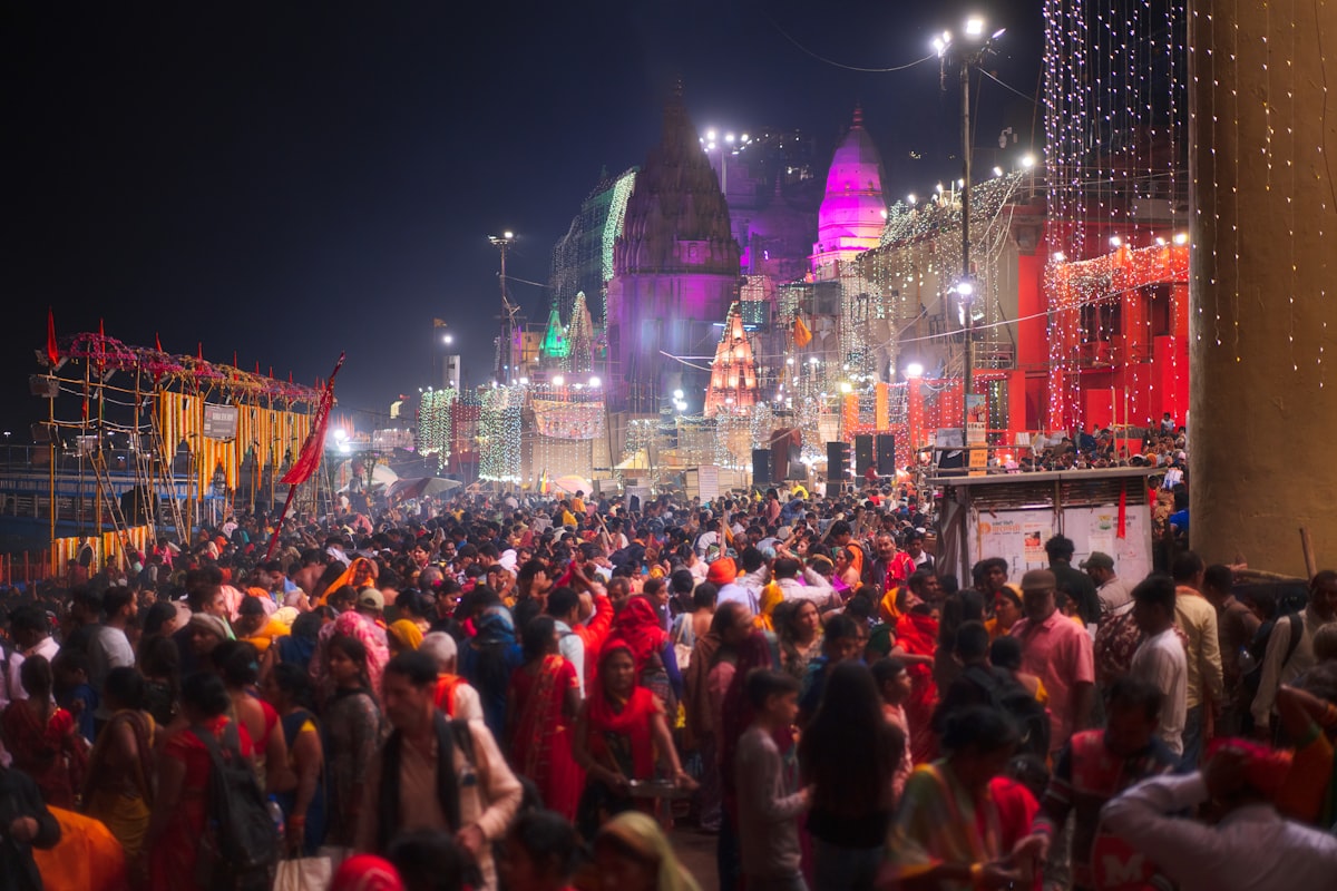 Crowd gathered at a brightly lit festival by a river