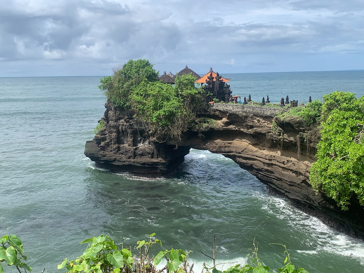 Temple on a rocky island arch over the ocean