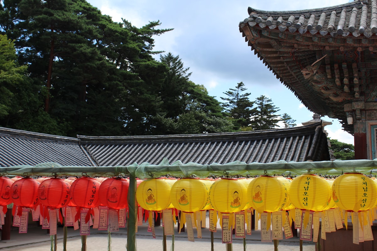 a row of yellow and red lanterns in front of a building