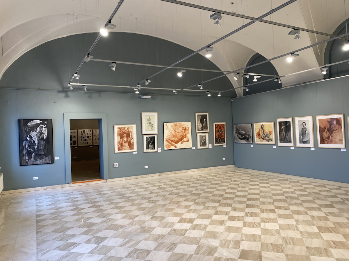 Art is displayed in an elegantly lit gallery.