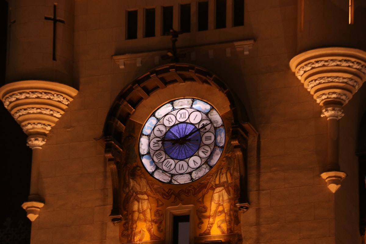 A close-up of a clock tower at night