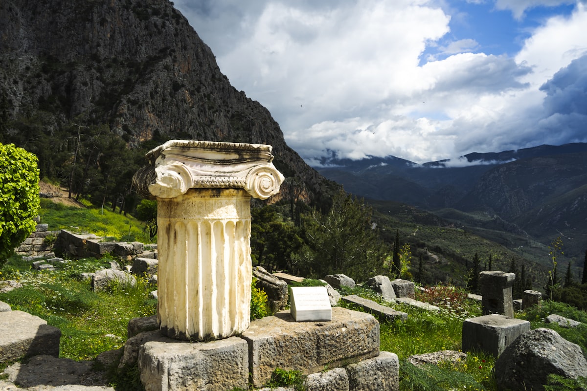 Ancient greek ruins with a column and mountains.