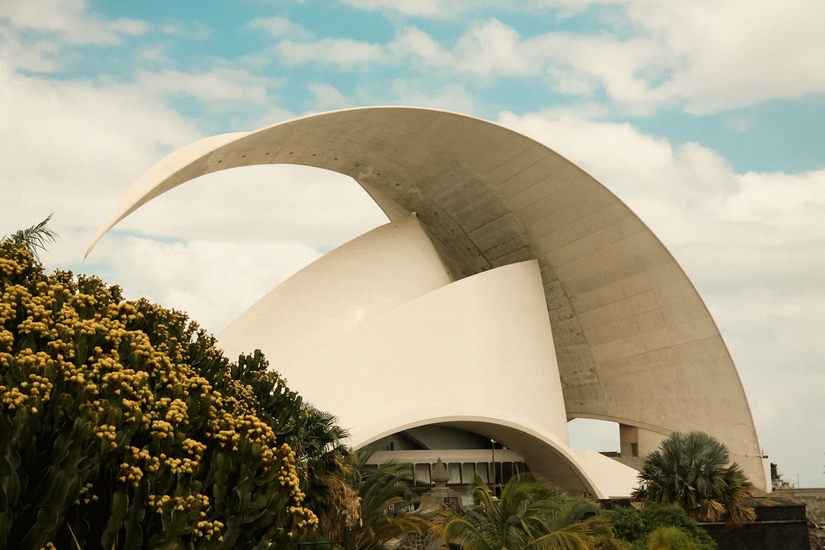 Modern white building with curved roof and trees