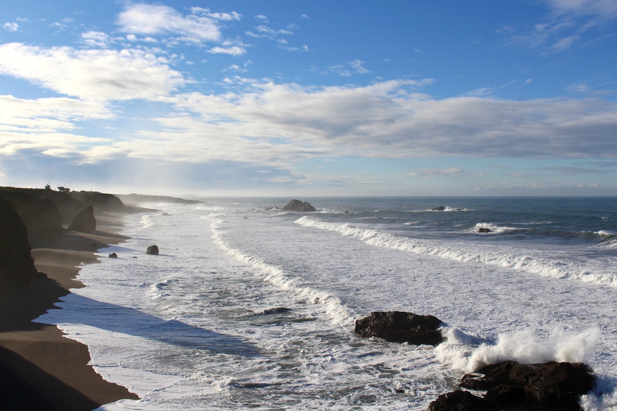a view of a beach with waves coming in to shore