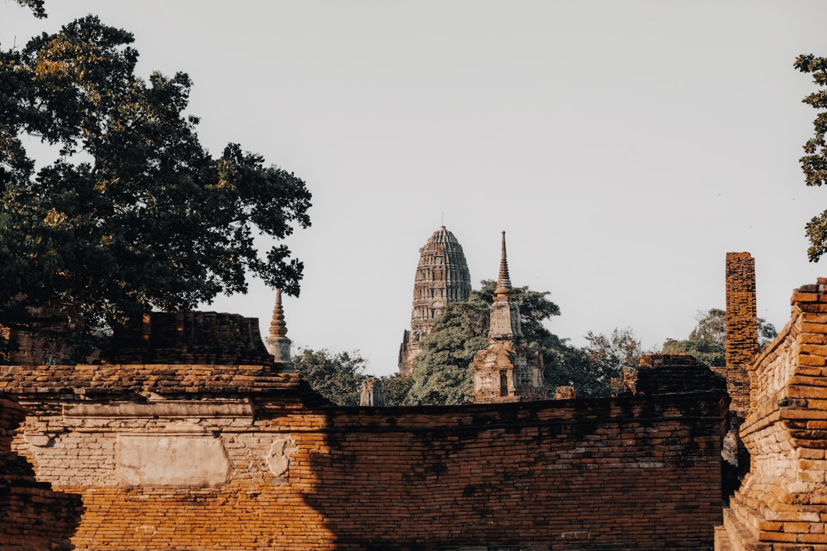 Ancient brick ruins with temple spires in background.