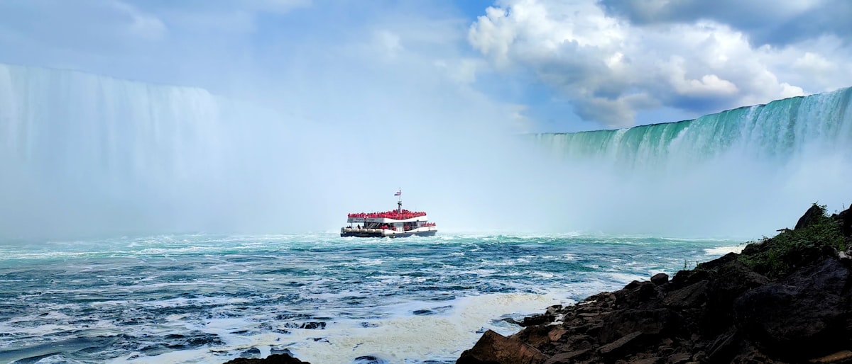 A boat in a body of water near a waterfall