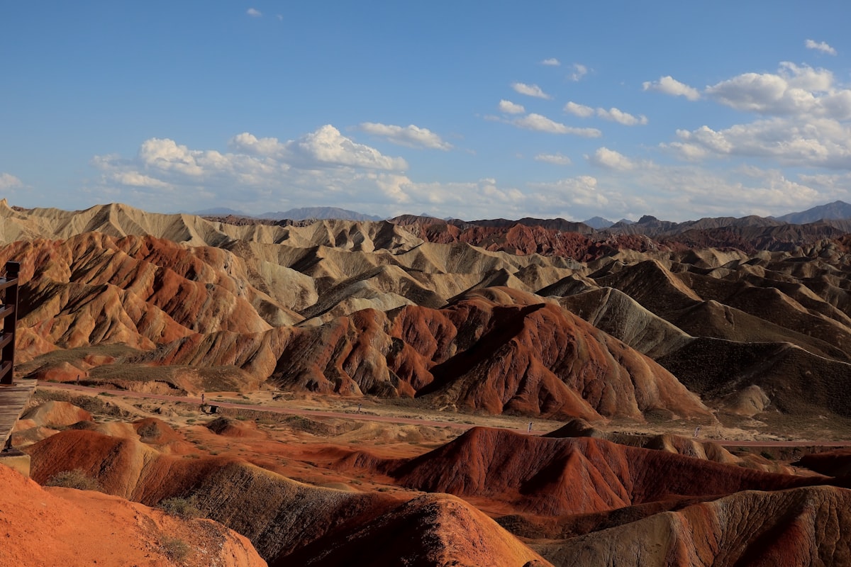 Colorful rolling hills under a blue sky with clouds