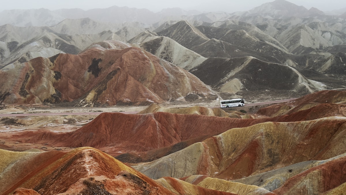 Colorful mountains with a bus on the horizon.