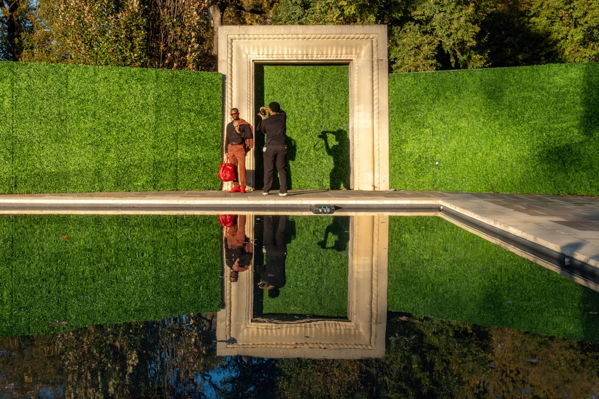 Two people stand in a doorway reflected in water
