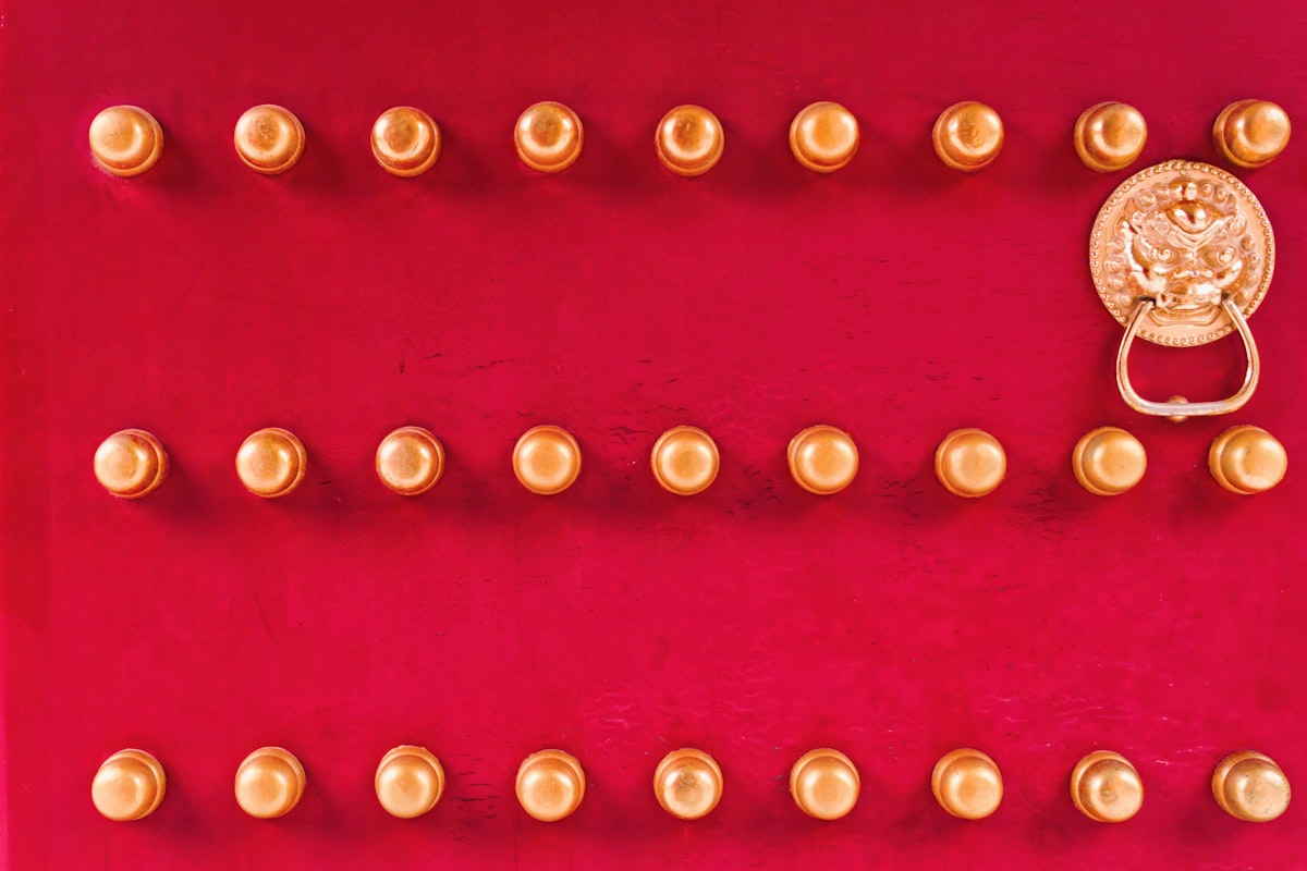 Red door with golden studs and lion head knocker