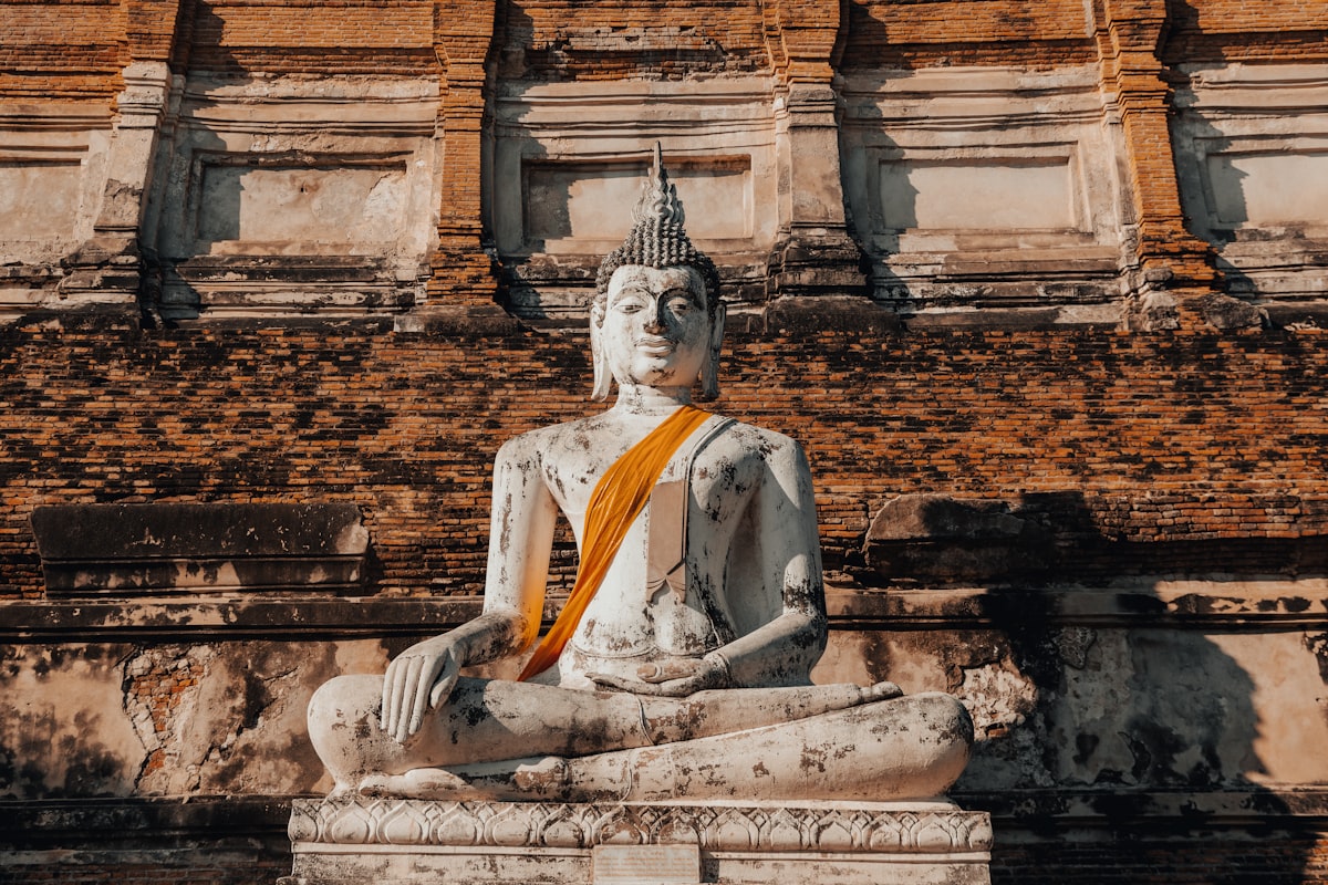 A seated buddha statue with orange cloth