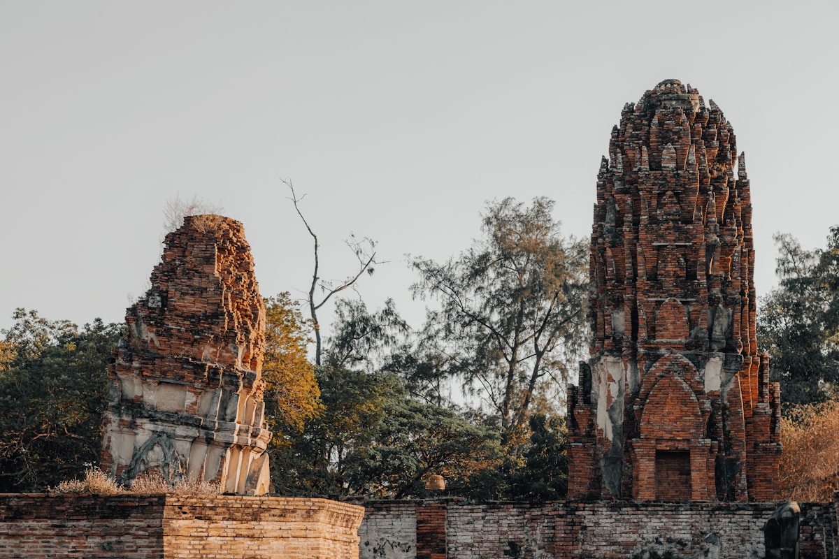 Ancient brick ruins with trees under a clear sky.