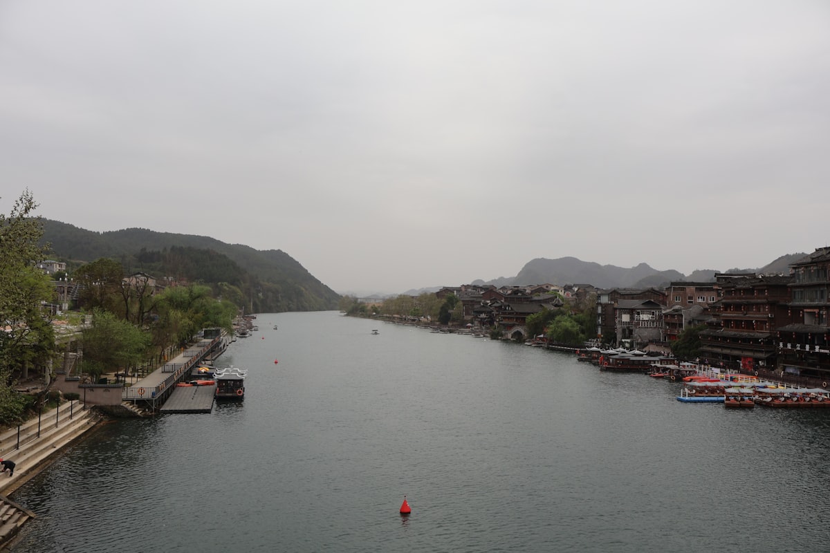 Wide river flows past a town nestled among hills.
