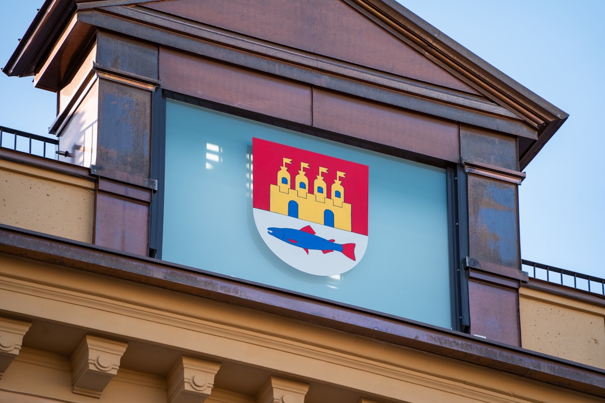 A coat of arms is on a building's exterior.