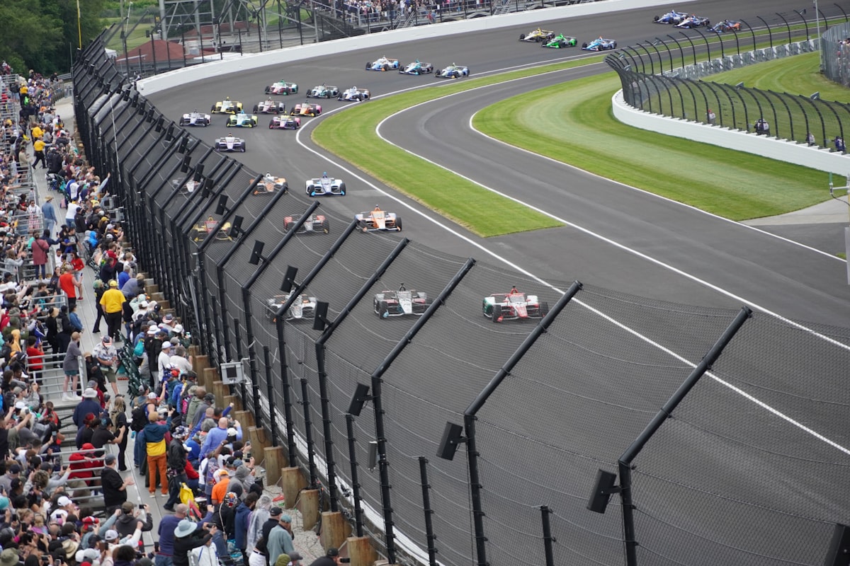 Race cars speed around a track during an indy 500.