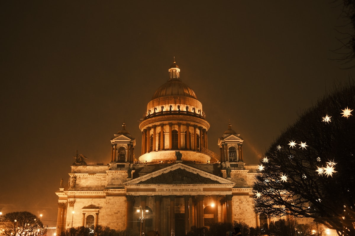 A building lit up at night with snow on the ground