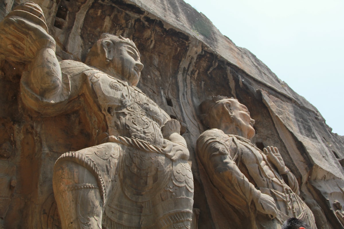 Ancient stone carvings of figures on a cliff face.
