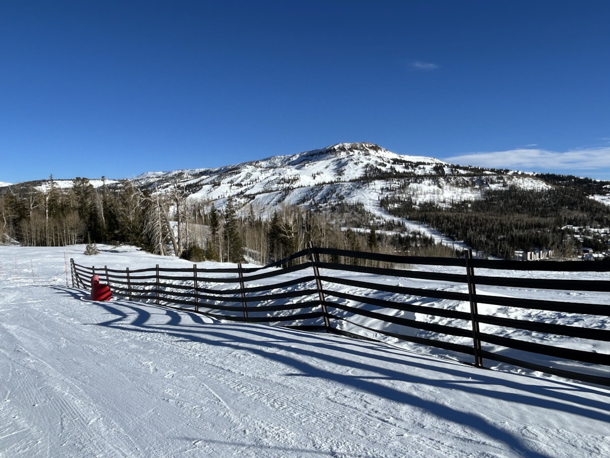Snowy mountain landscape with a wooden fence