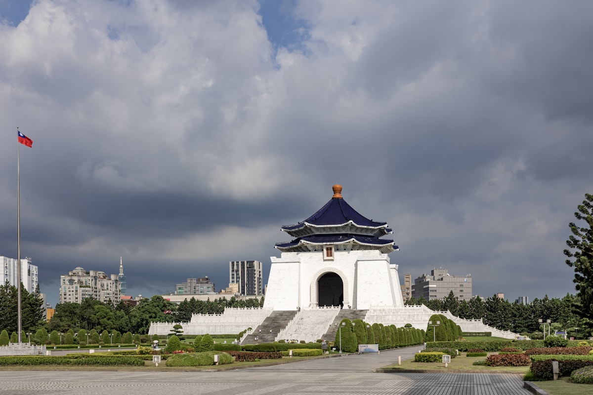 White memorial building with blue roof under clouds
