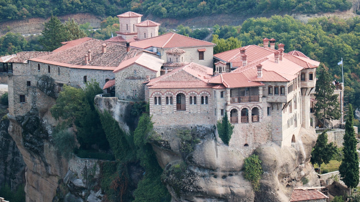 a castle on top of a cliff surrounded by trees